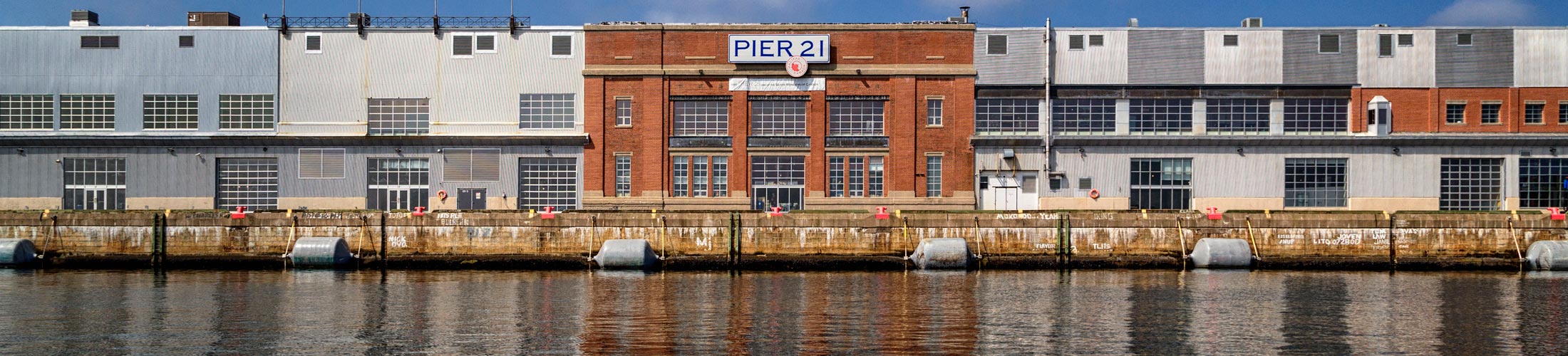 From the Atlantic Ocean, the Pier 21 building stands out from the other buildings along the Halifax seaport.