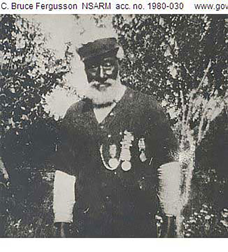 Archival image of an African American with decorated medals on his shirt.