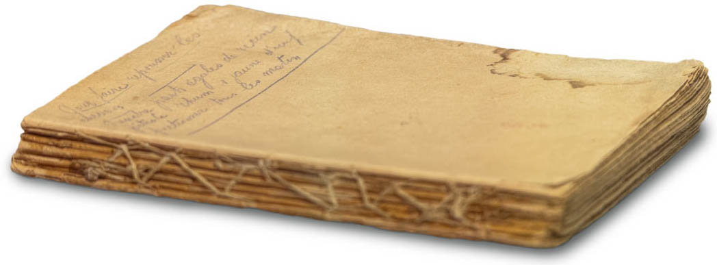 A coverless book, with pages sewn together along the spine, there is handwriting and a stain on the yellowed front page.