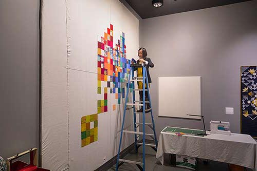 Andrea attaches the fabric block to the wall