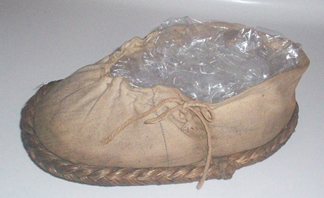 Close up of a moccasin-like shoe with stitching on the side.