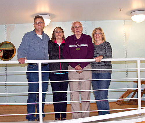 Two couples stand together in a hallway.