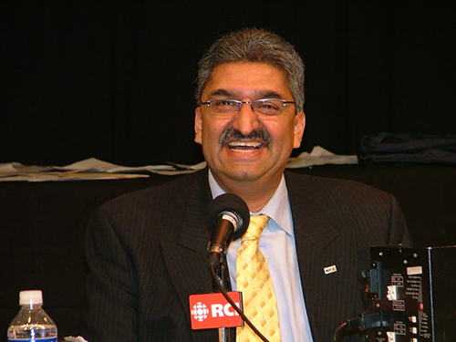 Head and shoulder photo of a man speaking into a mike.