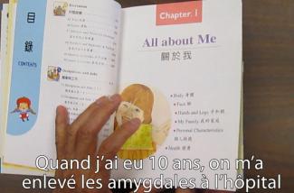 A hand can be seen leafing through a children's book.
