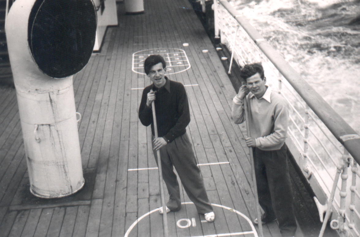 Two young men playing on deck of the ship, as viewed from the next level up.