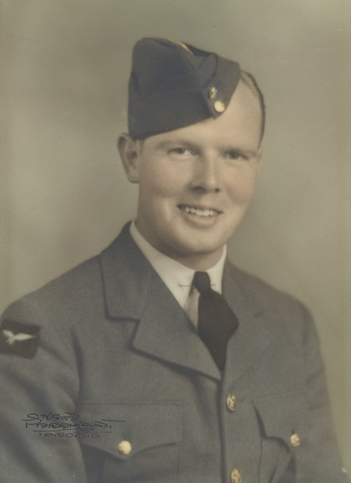 Portrait of a young man in a military uniform and hat.
