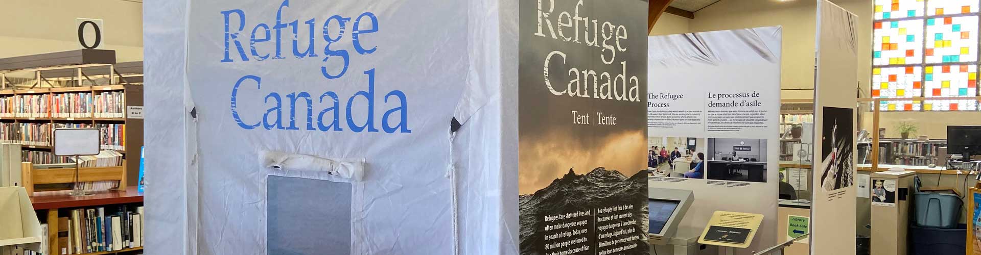 ‘Refuge Canada’ is printed on the grey fabric of a full-size tent panel.