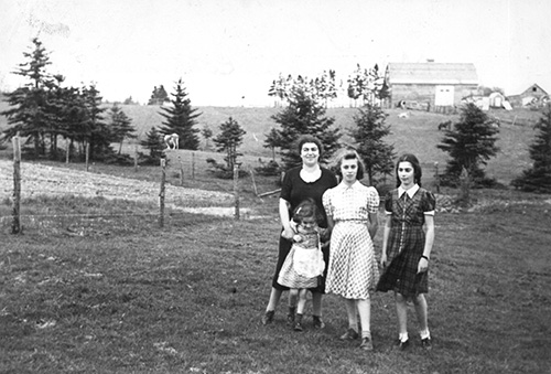 Trois filles sur l’herbe avec une jeune femme.