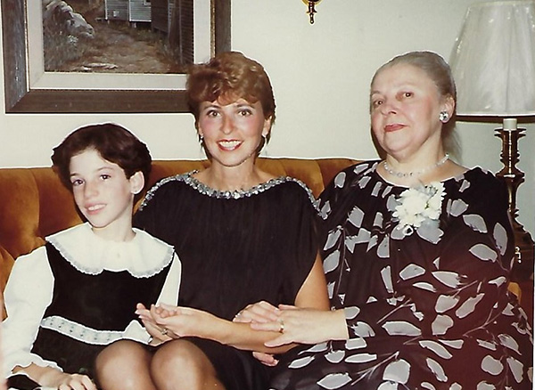 Three young women are sitting on a couch.