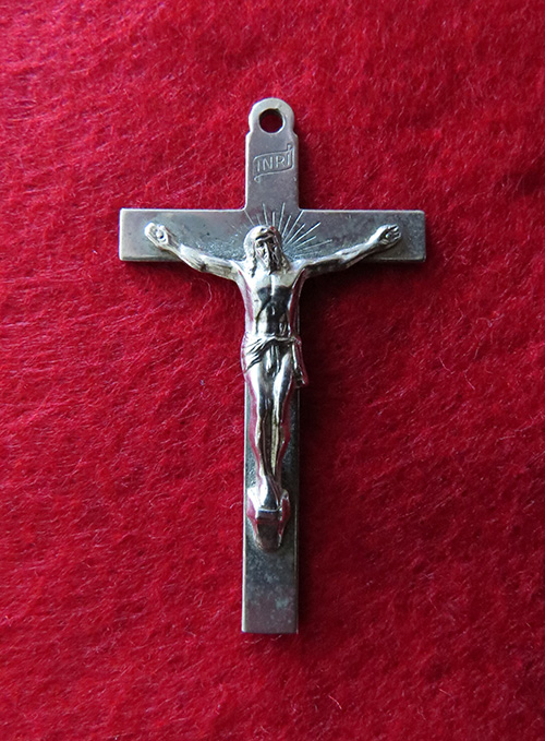 A religious cross with Jesus Christ on a red background.