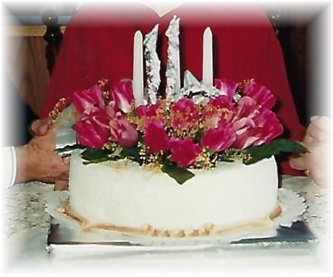 A decoratve white cake covered in roses.